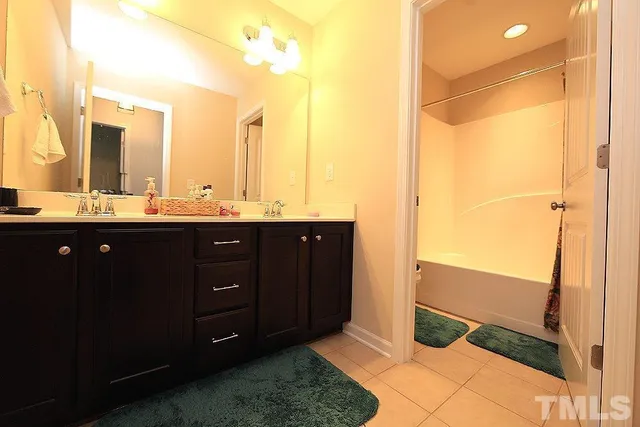 a bathroom with a double vanity sink and a mirror