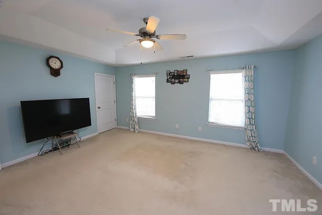 an empty room with windows and flat screen tv