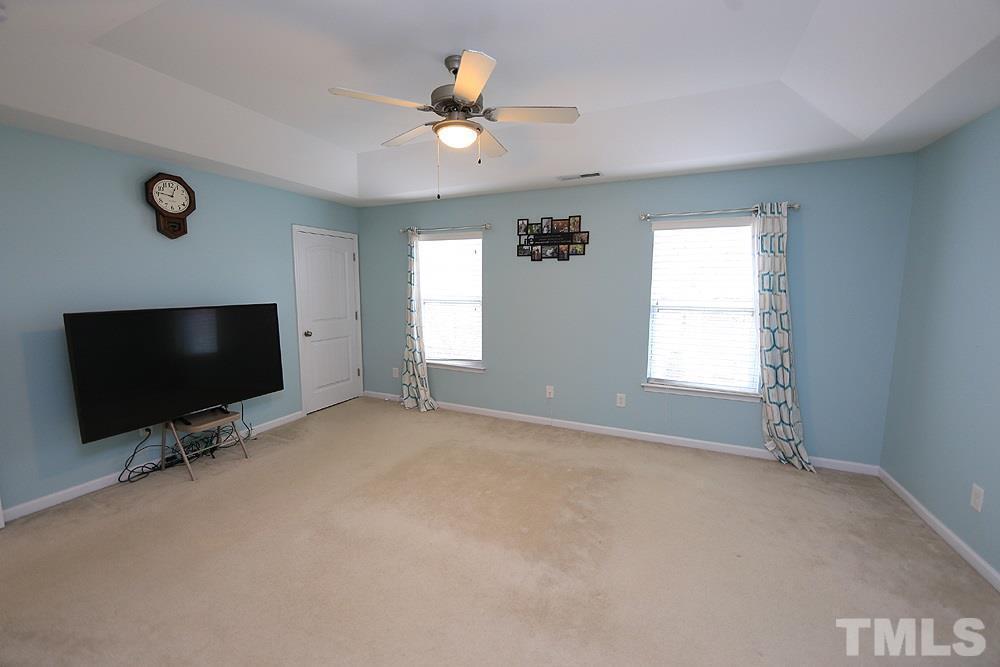2422 Memory Ridge Drive Raleigh, NC 27606 - Photo 10 of 19 an empty room with windows and flat screen tv