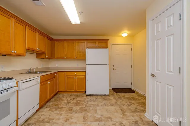 a kitchen with a refrigerator sink and cabinets