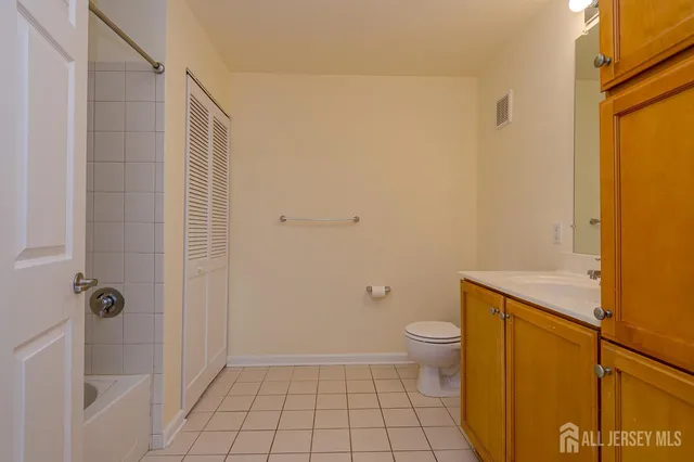 a bathroom with a granite countertop toilet and a shower