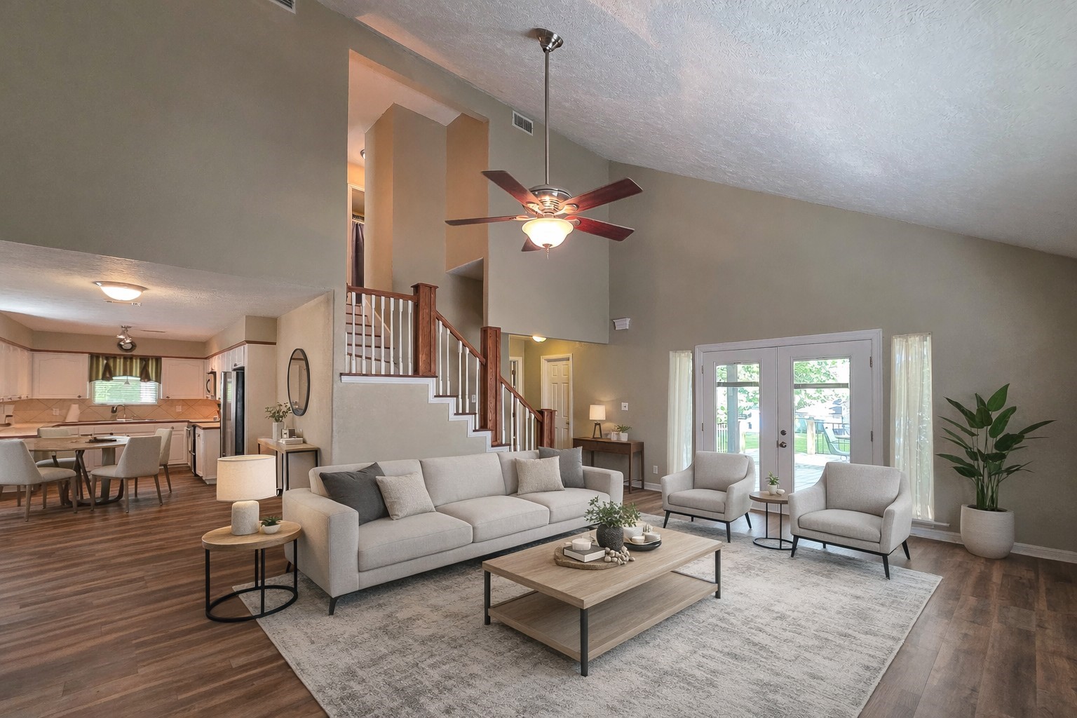 145 Cypress Road Livingston, TX 77351 - Photo 16 of 16 This spacious living area features high ceilings with a ceiling fan, cozy leather sofas, and abundant natural light from large windows and glass doors. The open floor plan connects to the kitchen and dining area, and a staircase leads to the upper level, enhancing the home's welcoming atmosphere.