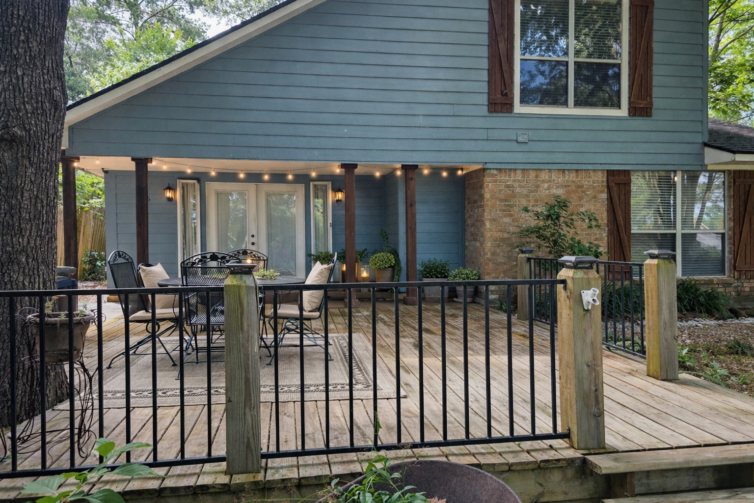 145 Cypress Road Livingston, TX 77351 - Photo 11 of 16 Charming two-story home with a spacious wooden deck, perfect for outdoor entertaining. Features include large windows, and a cozy patio area surrounded by greenery and a few peaks at the lake from the front porch.