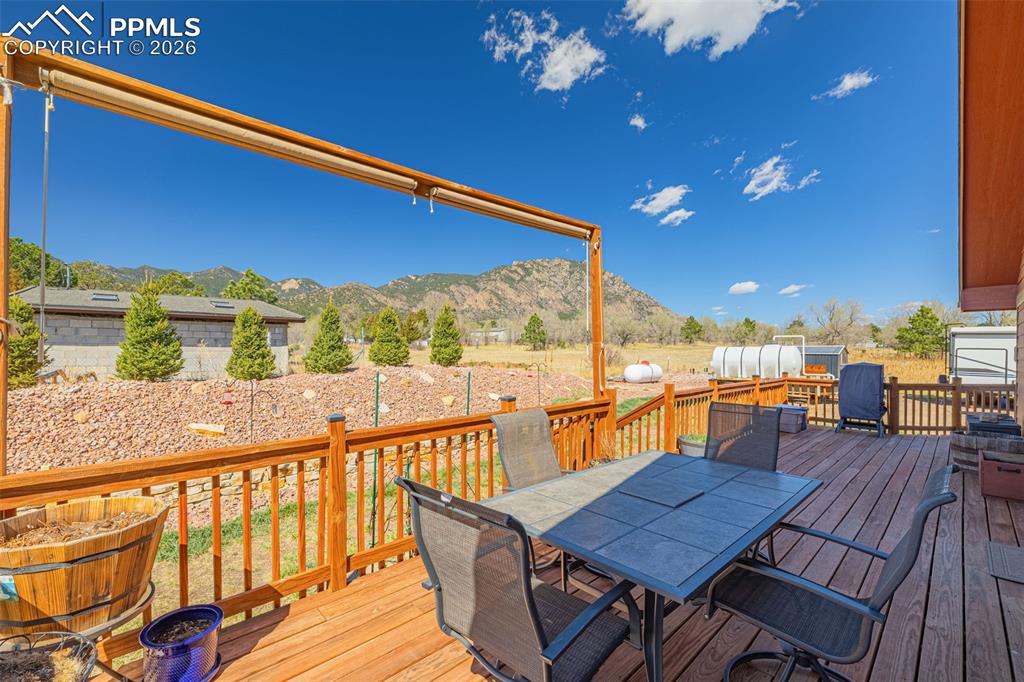 8480 Delaware Road Colorado Springs, CO 80926 - Photo 30 of 49 Wooden deck with outdoor dining space and a mountain view