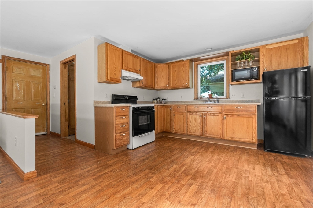 38 Pickering Street Danvers, MA 01923 - Photo 19 of 39 a kitchen with stainless steel appliances granite countertop a refrigerator a sink dishwasher a stove with wooden cabinets and floor