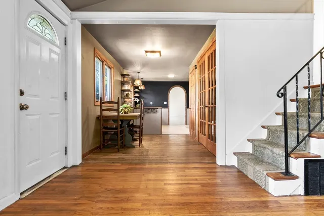 a view of a hallway with wooden floor and staircase