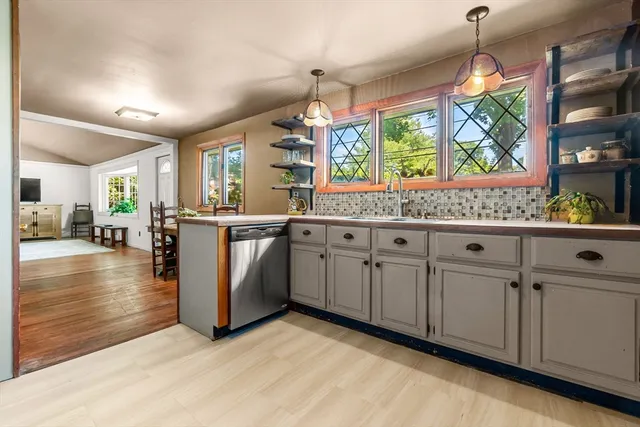 a kitchen with white cabinets and window