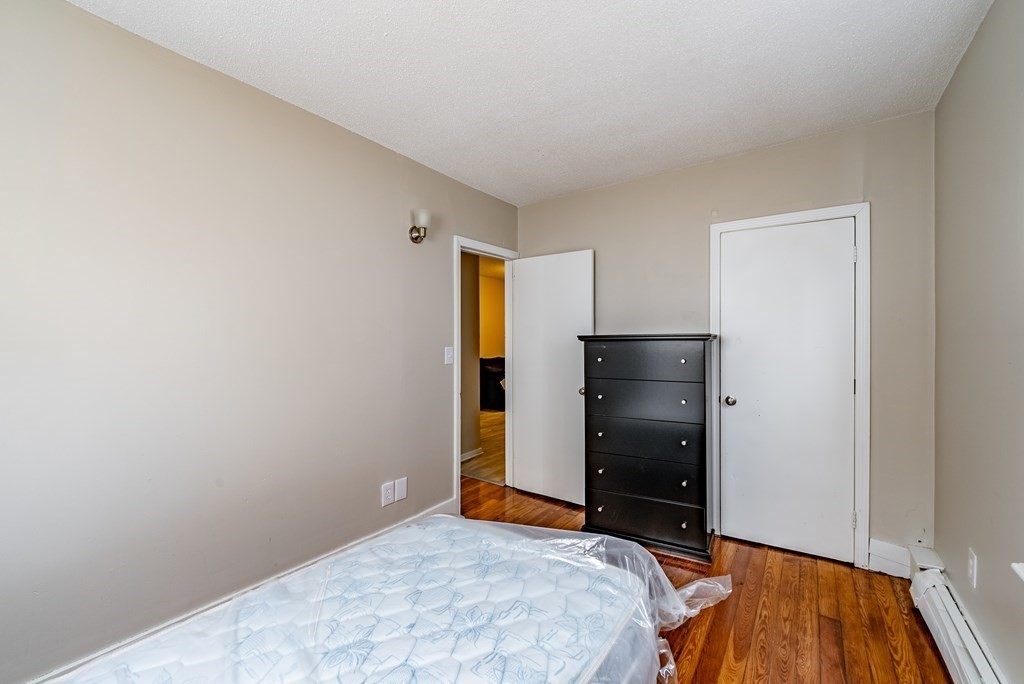 254-256 Main Street Springfield, MA 01151 - Photo 12 of 34 a bedroom with a bed and wooden floor