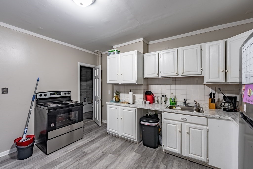 254-256 Main Street Springfield, MA 01151 - Photo 4 of 34 a kitchen with stainless steel appliances granite countertop a stove top oven a sink dishwasher and cabinets with wooden floor
