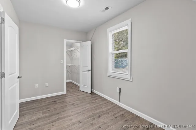 an empty room with closet and windows