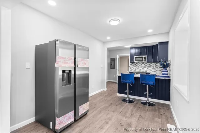 a kitchen with stainless steel appliances granite countertop a refrigerator and a stove top oven