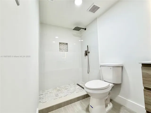 a bathroom with a sink a toilet and a shower