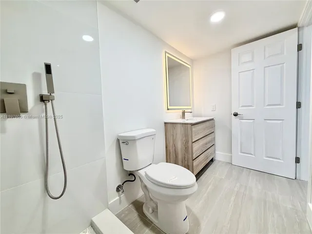 a white toilet sitting next to a bathroom sink