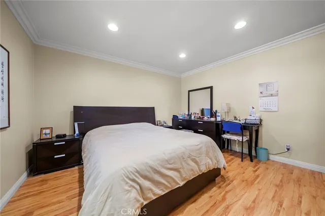 a bedroom with a bed and a wooden floor