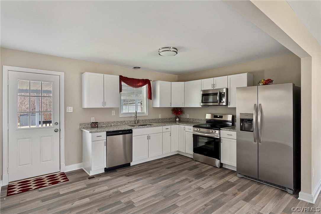988 3 Notch Road Kents Store, VA 23084 - Photo 8 of 32 Kitchen featuring white cabinets, hardwood / wood-