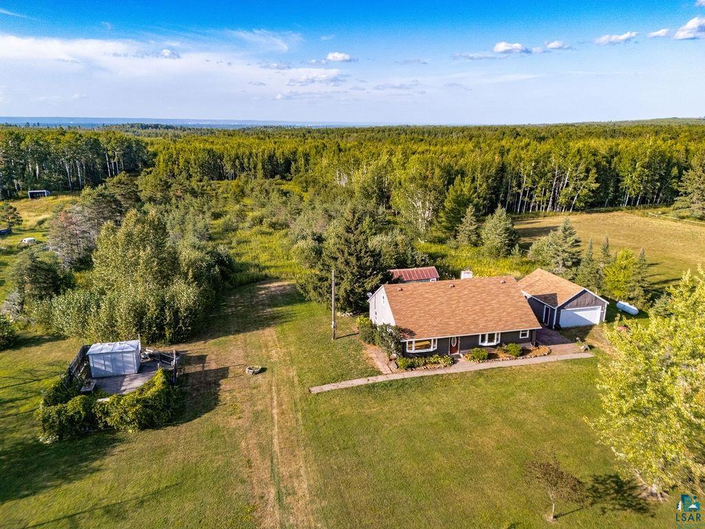 3949 East County Rd B Superior, WI 54880 - Photo 42 of 50 Single-story residence with a brown shingle roof, a detached two-car garage, and an expansive lawn