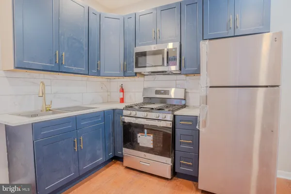 a kitchen with stainless steel appliances granite countertop a refrigerator stove a sink and dishwasher with wooden cabinets