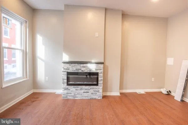 a view of an empty room with a window and fire place