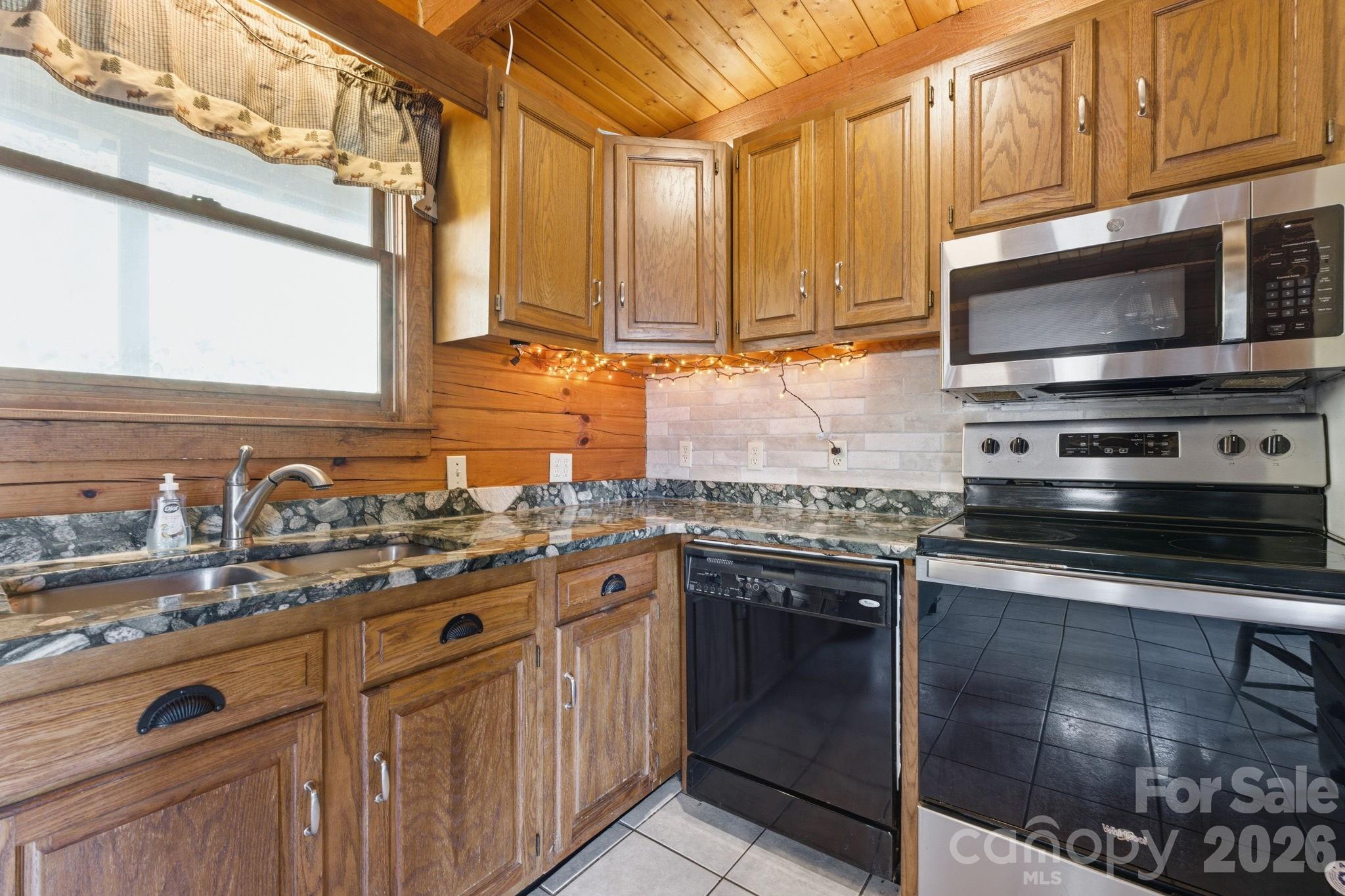 1837 East Alarka Road Bryson City, NC 28713 - Photo 18 of 34 a kitchen with stainless steel appliances granite countertop a sink and a stove