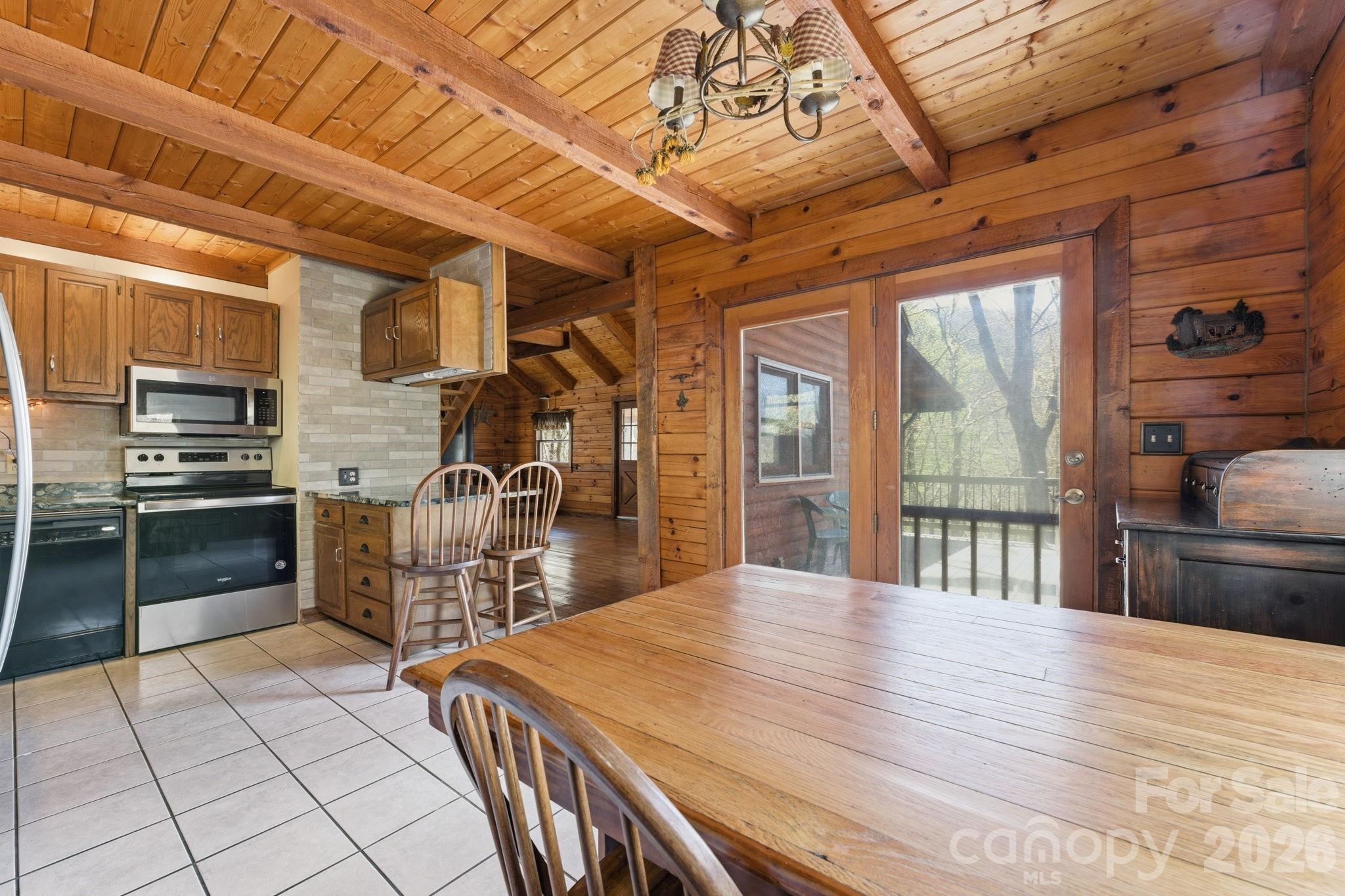 1837 East Alarka Road Bryson City, NC 28713 - Photo 31 of 34 a kitchen with stainless steel appliances granite countertop a stove a sink dishwasher and cabinets