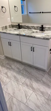 a kitchen with granite countertop a sink and a white cabinets