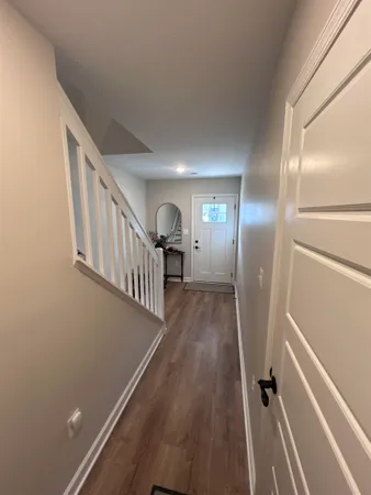 a view of a hallway with wooden floor and staircase