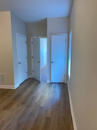 a view of a hallway with wooden floor