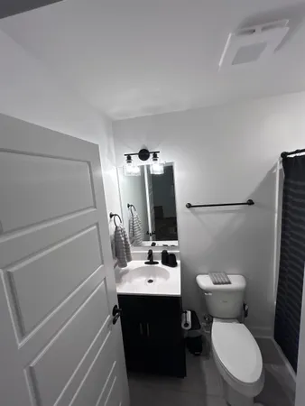 a bathroom with a sink vanity mirror and toilet