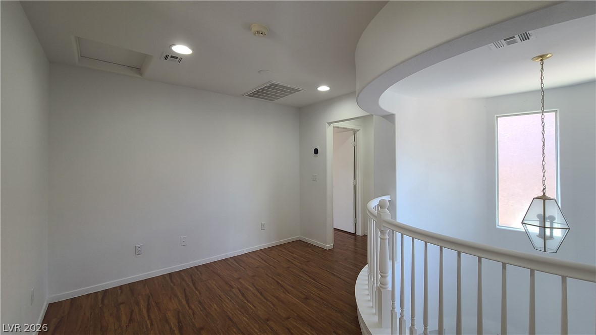 8944 Rutherford Grove Street Las Vegas, NV 89148 - Photo 13 of 35 A graceful staircase with classic balusters ascends to a landing illuminated by recessed lighting and a charming pendant fixture.