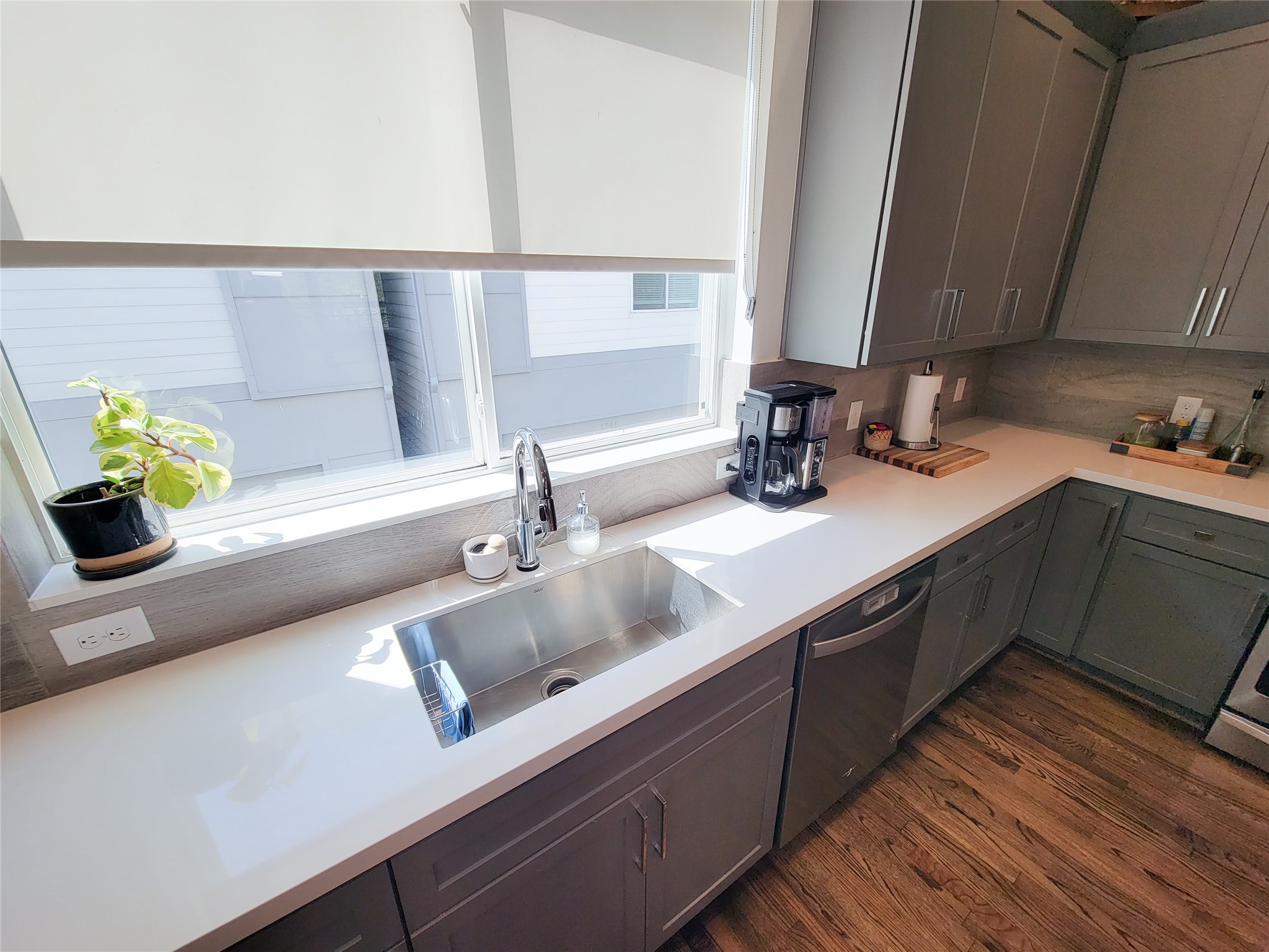 1705 Eado Point Lane Houston, TX 77003 - Photo 30 of 50 Bright kitchen with modern gray cabinets, sleek white countertops, and stainless steel appliances. Large window provides plenty of natural light.