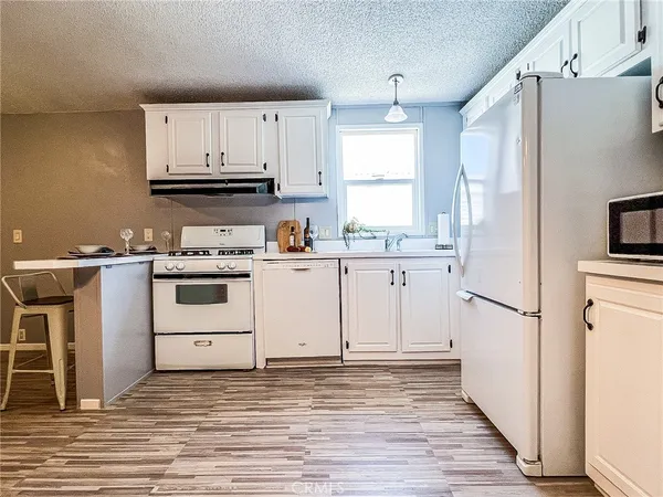 a kitchen with white cabinets and white appliances