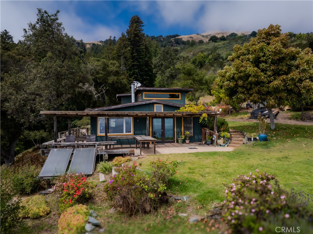 0 Morning Glory Ranch Big Sur, CA 93920 - Photo 9 of 35 a view of a patio with table and chairs under an umbrella with large trees