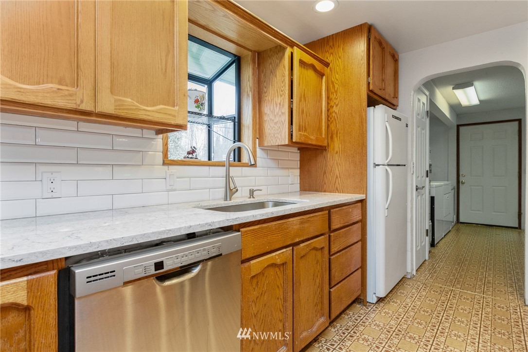 15408 Southeast Jones Road Renton, WA 98058 - Photo 12 of 40 a kitchen with stainless steel appliances granite countertop a sink and cabinets