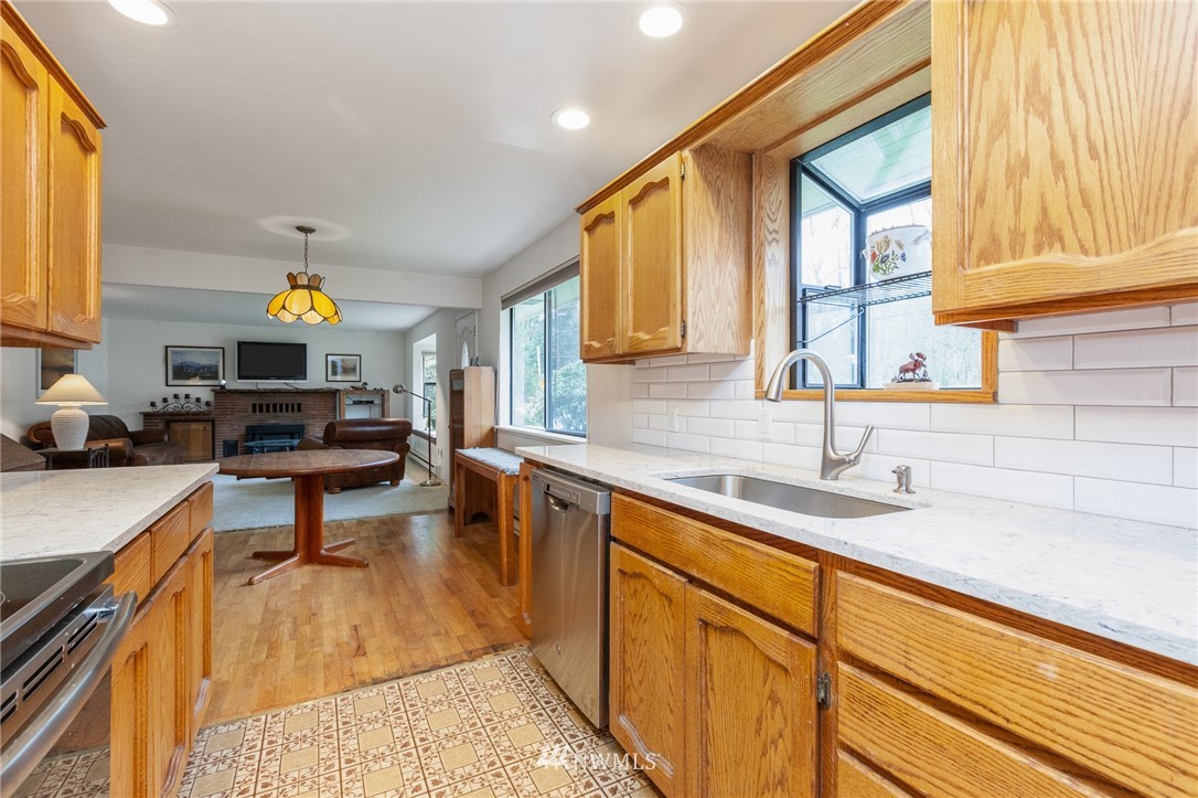 15408 Southeast Jones Road Renton, WA 98058 - Photo 14 of 40 a living room with stainless steel appliances kitchen island granite countertop a sink a stove and a dining table view