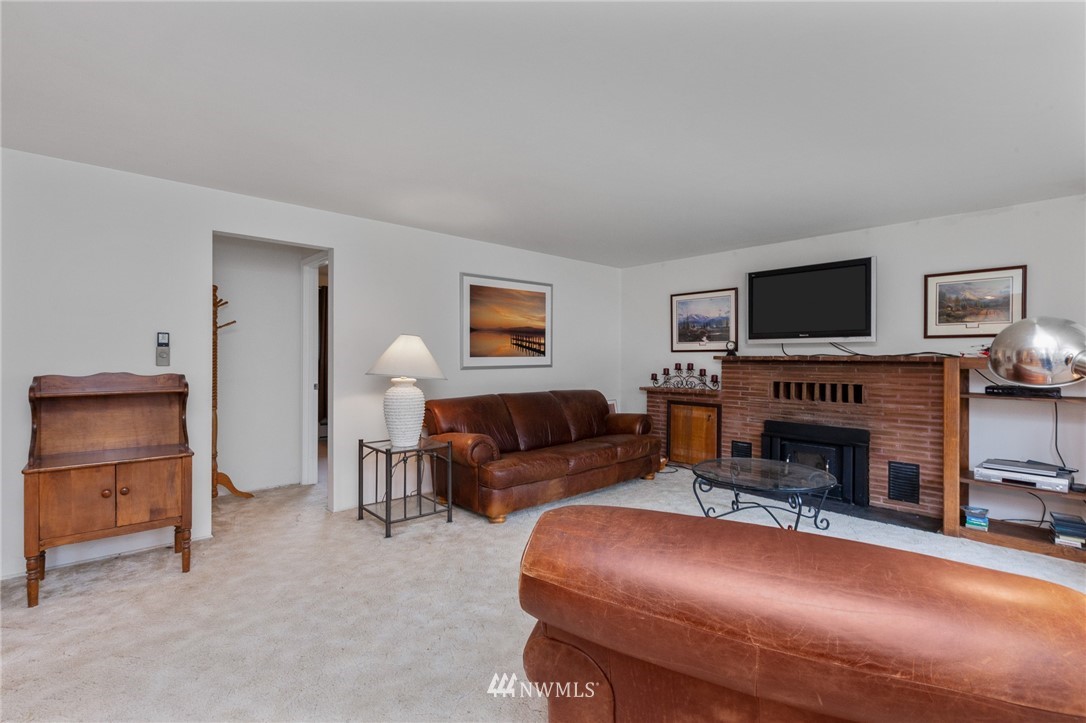 15408 Southeast Jones Road Renton, WA 98058 - Photo 3 of 40 a living room with furniture a fireplace and a flat screen tv