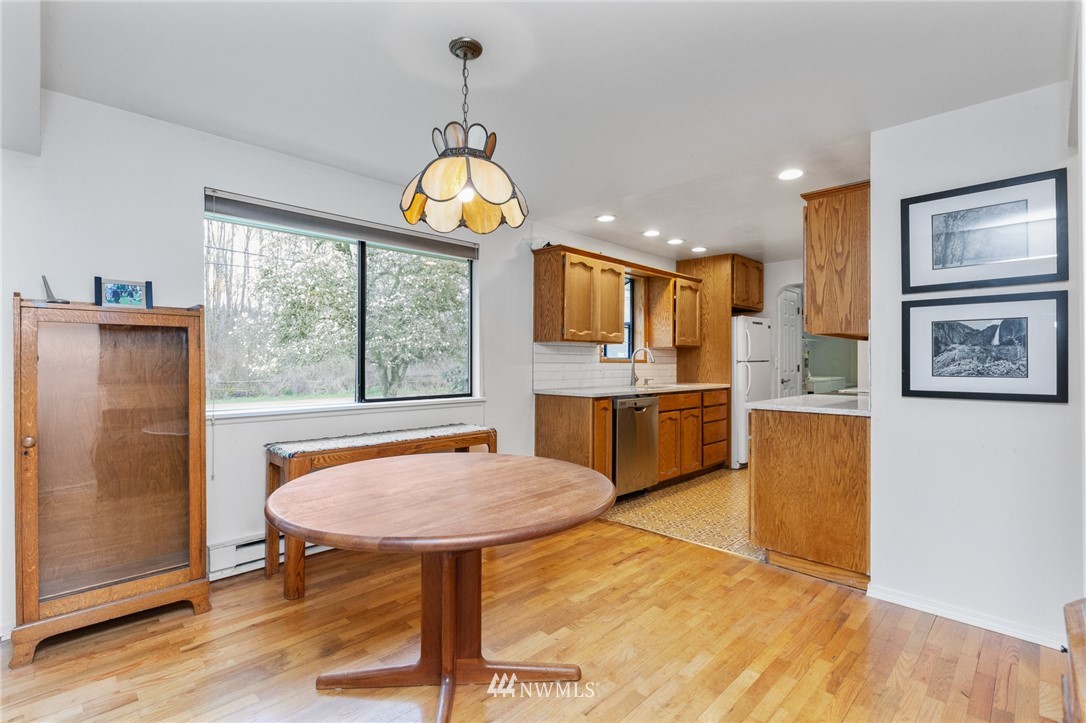 15408 Southeast Jones Road Renton, WA 98058 - Photo 7 of 40 a view of a dining room kitchen with furniture a chandelier and wooden floor