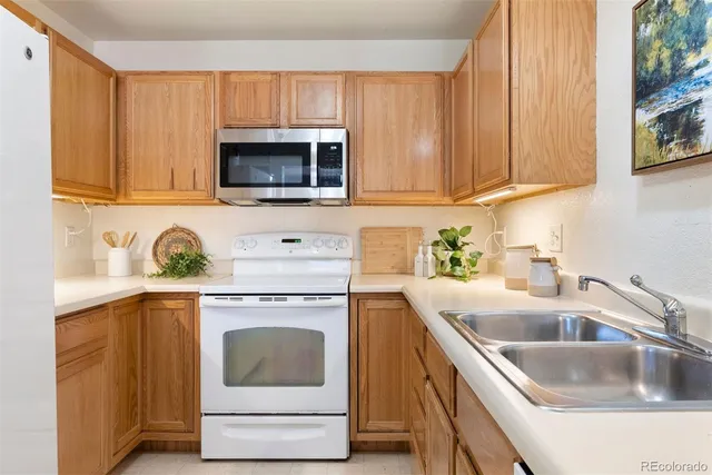 a kitchen with granite countertop a sink a stove and microwave