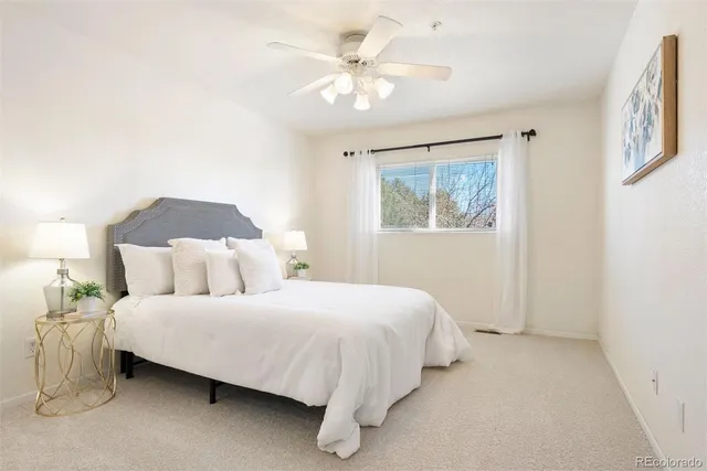 a bedroom with a bed and a ceiling fan