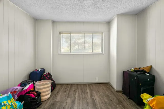 a bedroom with a bed and a lamp on dresser