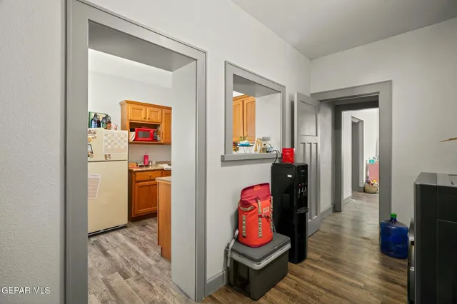a view of a hallway with wooden floor and a bathroom