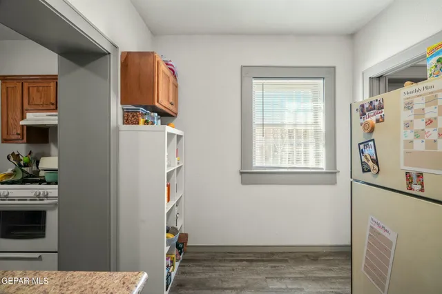 a view of a big room with wooden floor and a kitchen