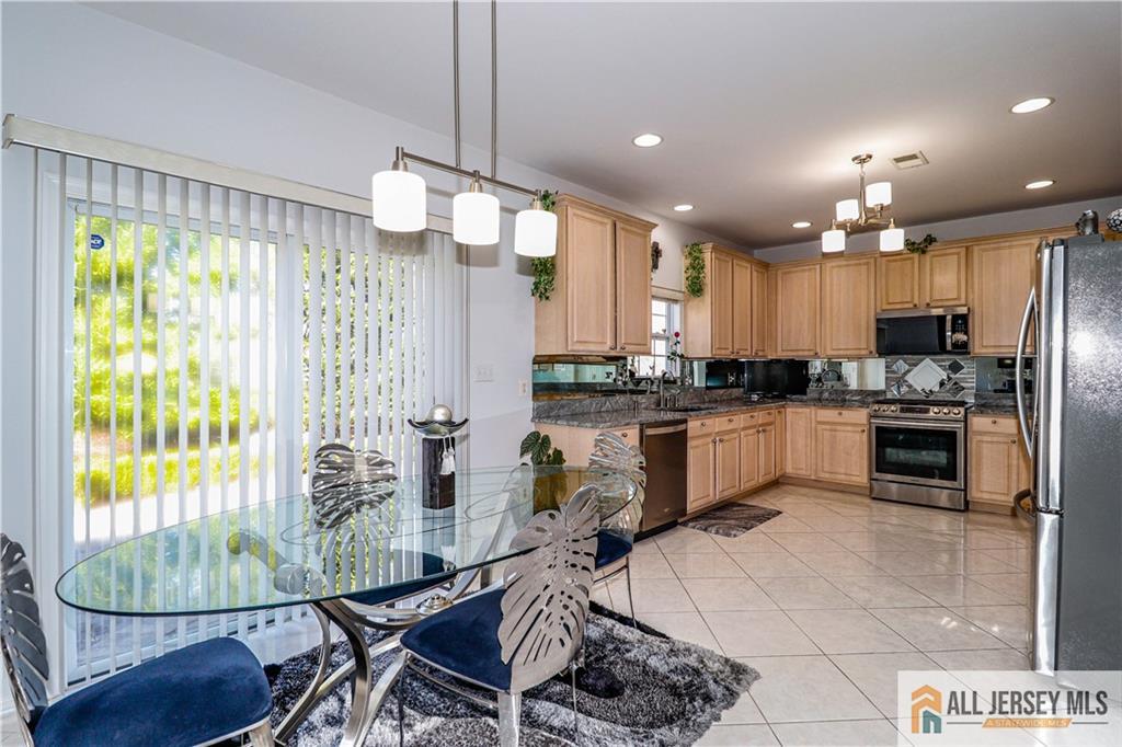 11 Markham Circle Old Bridge, NJ 08857 - Photo 12 of 61 a kitchen with stainless steel appliances kitchen island granite countertop a refrigerator a stove a sink dishwasher with a dining table and chairs