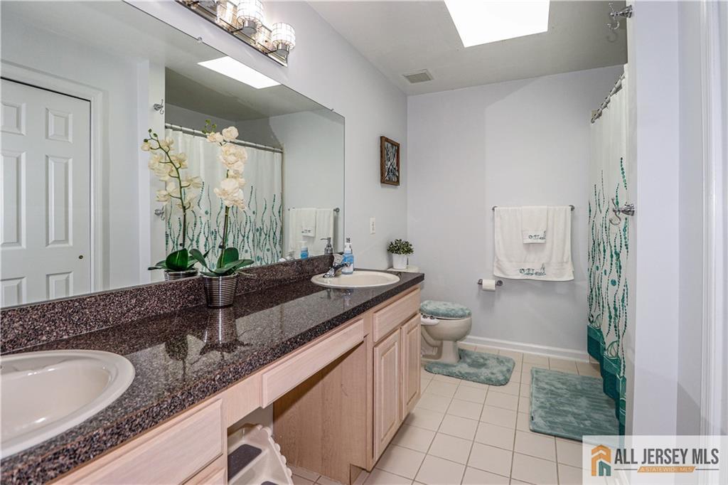 11 Markham Circle Old Bridge, NJ 08857 - Photo 32 of 61 a bathroom with a granite countertop sink a toilet a mirror and shower