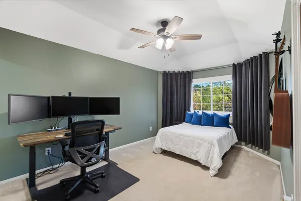 a bedroom with a bed window and a flat screen tv
