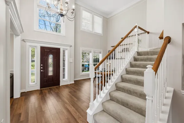 a view of staircase with white walls and a fireplace
