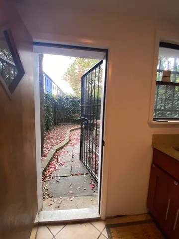 a backyard of a house with chairs and wooden fence
