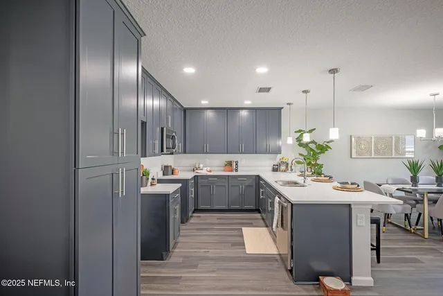a kitchen with a sink a refrigerator and wooden floor