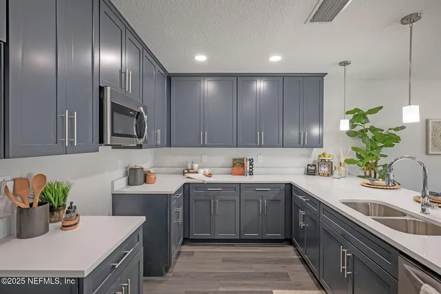a kitchen with kitchen island a sink stainless steel appliances and cabinets