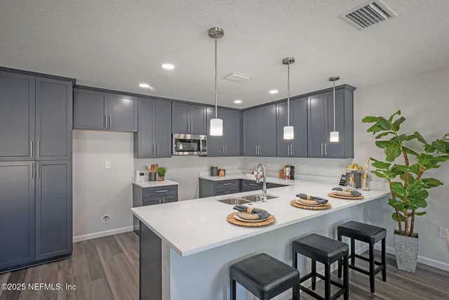 a kitchen with a table chairs sink and cabinets
