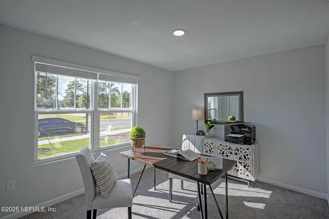 a view of a workspace with furniture and a window
